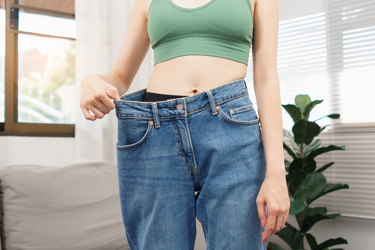 Woman in loose jeans when success with losing weight