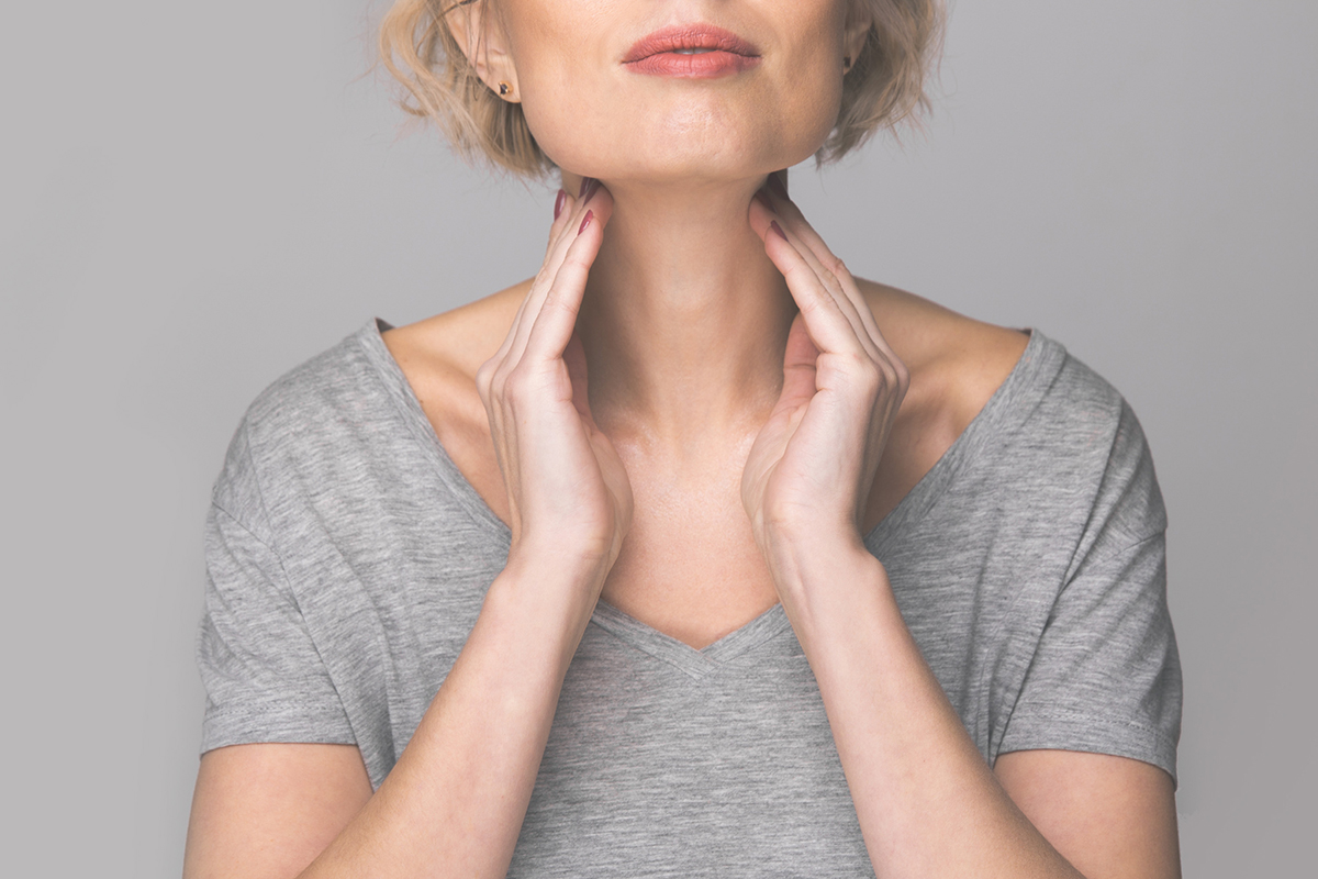 Female checking thyroid gland by herself